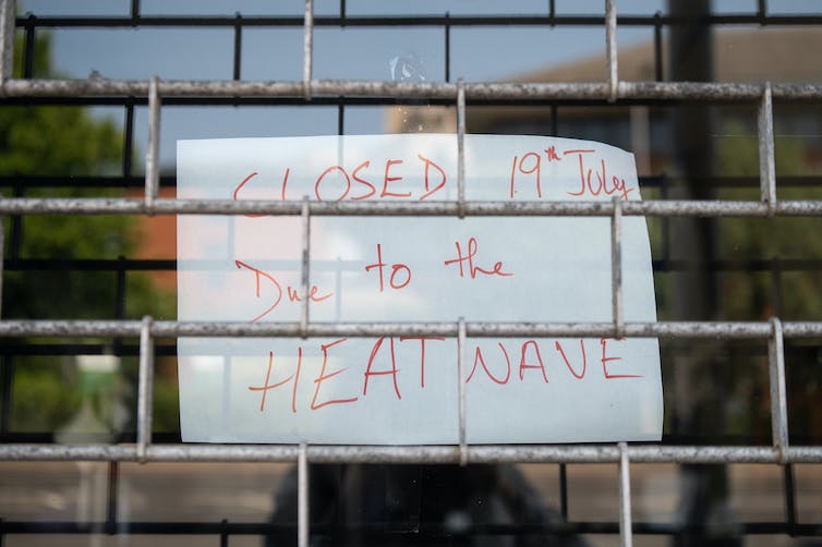 Handwritten sign saying business is closed due to heatwave.